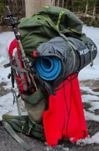 zerstörte Pulka hängt am Rucksack während einer Wintertrekkingtour